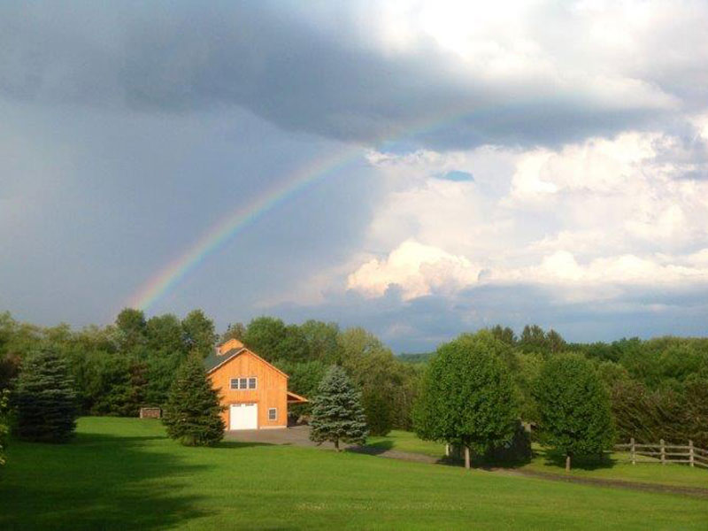 A picture of a Geobarn under a rainbow.