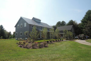 passive house, porch, garage, landscape, gray siding, cupola