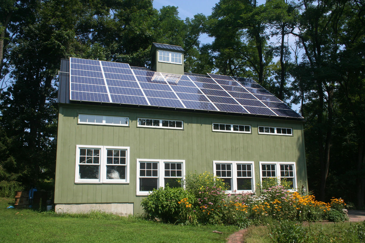 An exterior picture of a pottery studio, design and built by Geobarns, with solar panels and cupola on the roof.