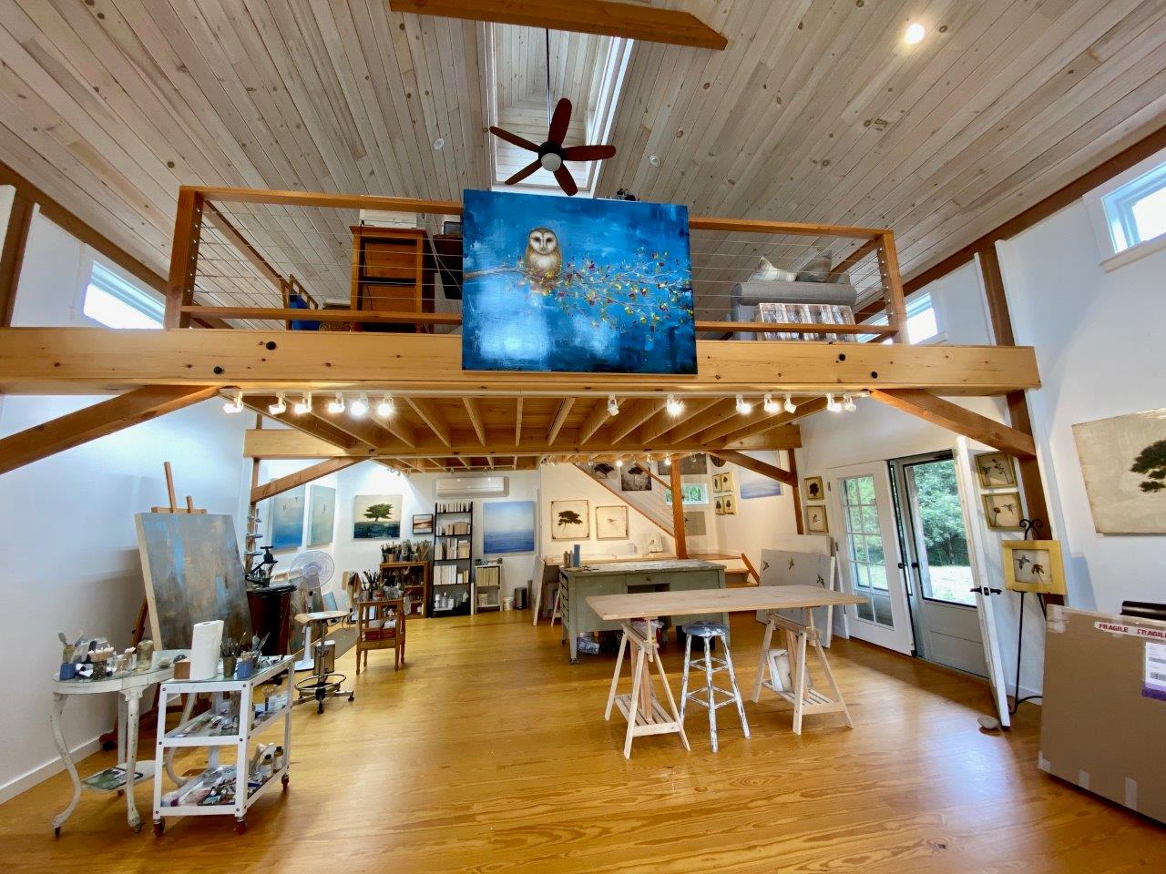 A picture of Jessica Pisano's art studio, designed and built by Geobarns, with a floating loft for an office and several of her paintings on display.