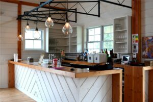 A picture of a wine bar in a Wedding Barn in Vermont with pendant lights made from old wine bottles