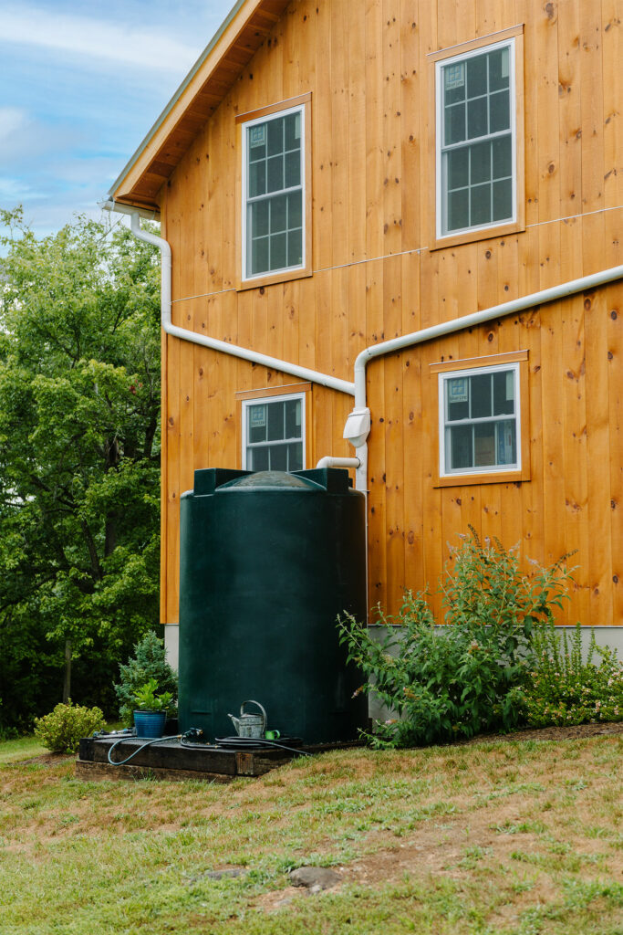 A picture of a rainwater collection system with gutters feeding into a storage tank for a nearby herb garden at the Virginia Homestead Barn designed and built by Geobarns.