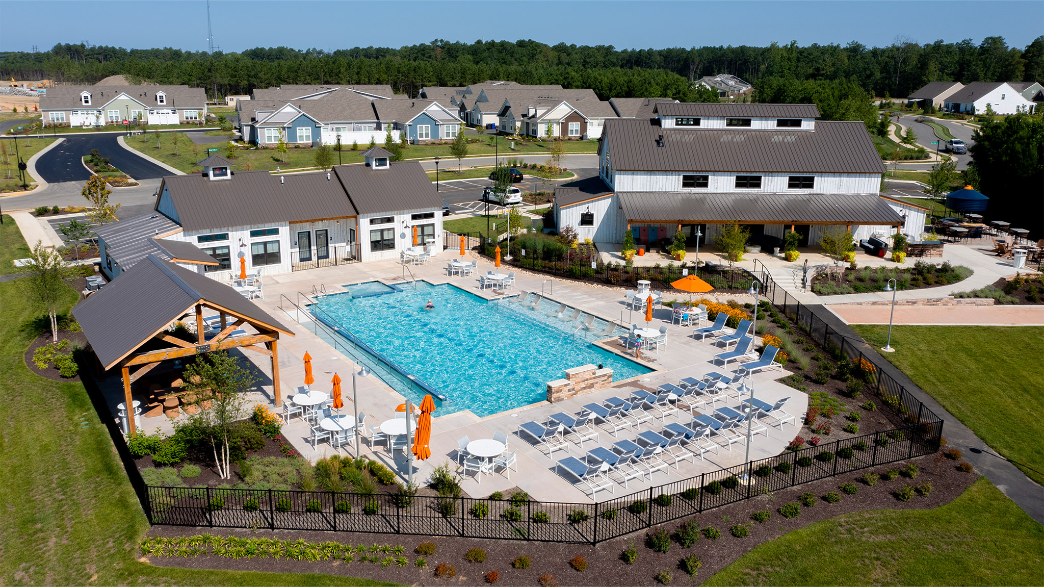 An aerial picture of the Farmhouse community center at Chickahominy Falls, designed and built by Geobarns, with community center, fitness center, pool pavilion, and community pool