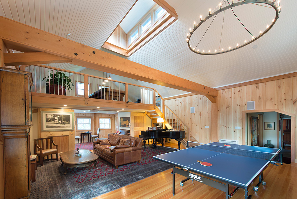 An interior picture of the Historic Carriage House, design and built by Geobarns, with a ping-pong table, home office, and loft for a pool table.