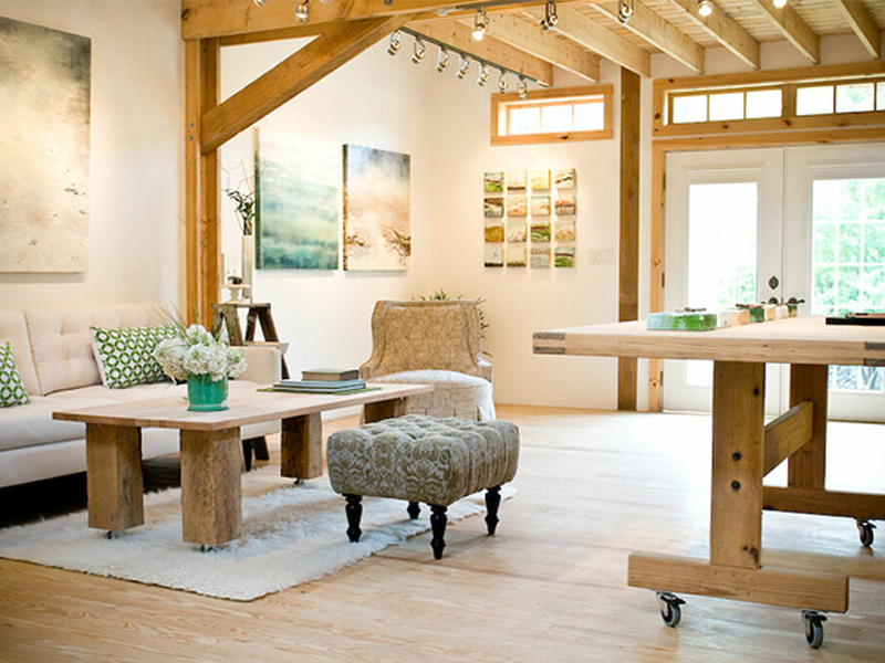 An interior picture of an art studio, design and built by Geobarns, with exposed timber framing and ceiling rafters, lots of natural light, and natural wood floors. 