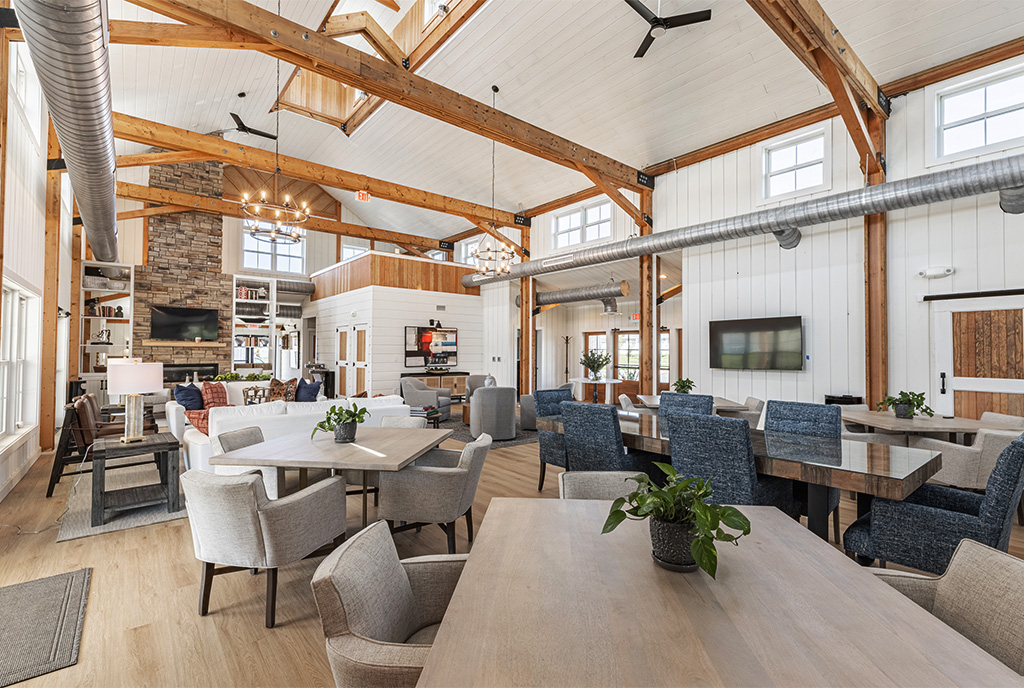 A picture of the interior of The Farmstead at Chickhominy Falls, designed and built by Geobarns, with exposed timber framing, white shiplap wood wall finishes, exposed air ducts, and a cupola above a vaulted ceiling.