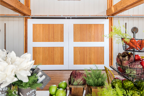 An interior picture of rolling barn doors that divide the meeting hall from the test kitchen at the Farmstead at Chickahominy Falls, designed and built by Geobarns.