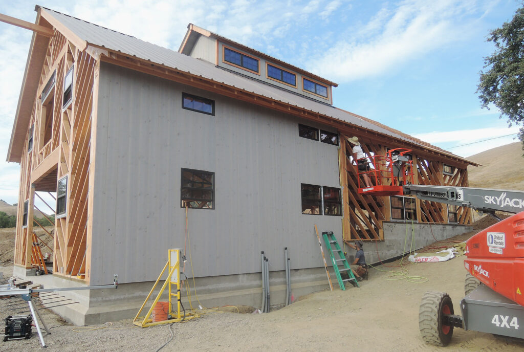 A Geobarn under construction with siding being installed to diagonal framing.