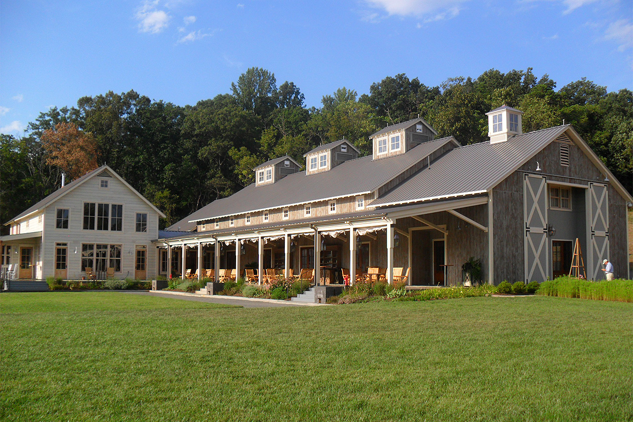 An exterior picture of Pippin Hill Farm and Vineyards, designed and built by Geobarns, features two interconnected Geobarns that recreate an old Virginia farmstead as a premier wedding and wine country destination.