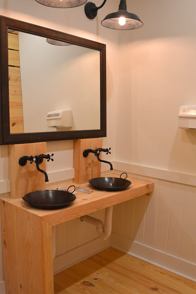 A picture of the vanity with 'iron skillet' style sinks and gooseneck lights at the Barn at Smuggler's Notch in Vermont