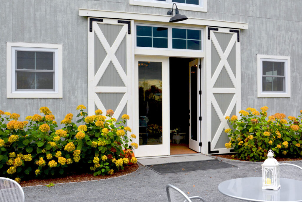 A picture of the entrance to the Barn at Smuggler's Notch with rolling barn door shutters, designed and hand-built by Geobarns