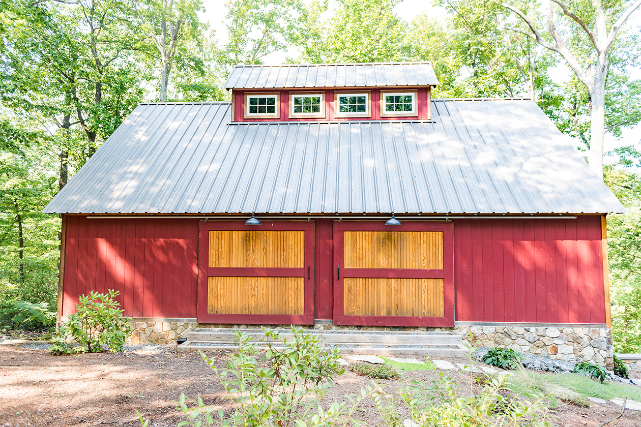 The Virginia Car and Shop Barn, designed and built by Geobarns at Bundoran Farm in Virginia, with barn red wood siding, silver metal roof, and Douglas fir trim