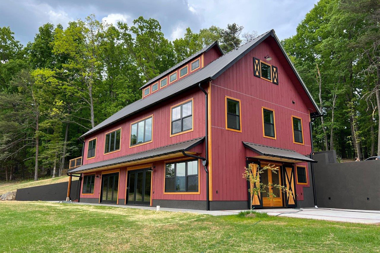 An exterior picture of the Virginia Wine Country recreational barn, designed by Geobarns, with wood siding in barn red stain, natural Douglas fir trim, and black accents.